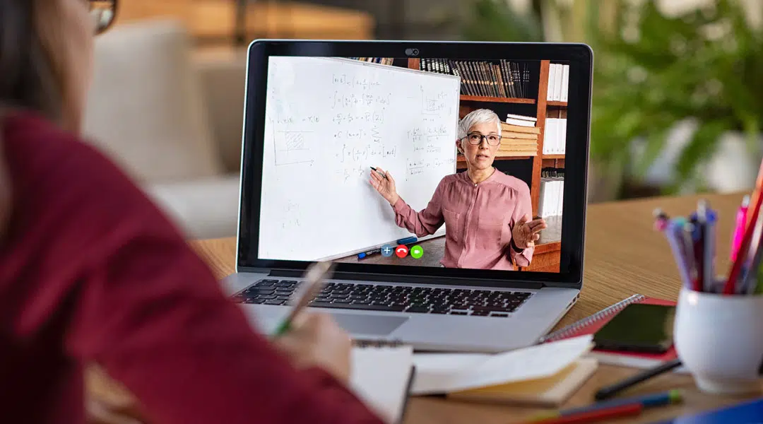 Un étudiant participe à un cours à distance avec un professeur lors d'un apprentissage synchrone